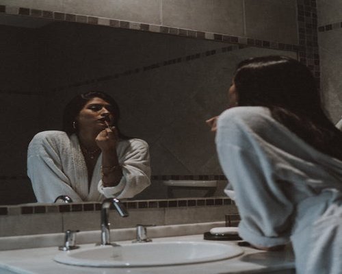 Persona en su rutina de la mañana frente al espejo